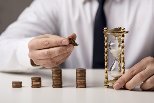 vista-frontal-del-empresario-con-monedas-y-reloj-de-arena